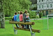 Die Kinder genießen ihre eigene Bank am Spielplatz